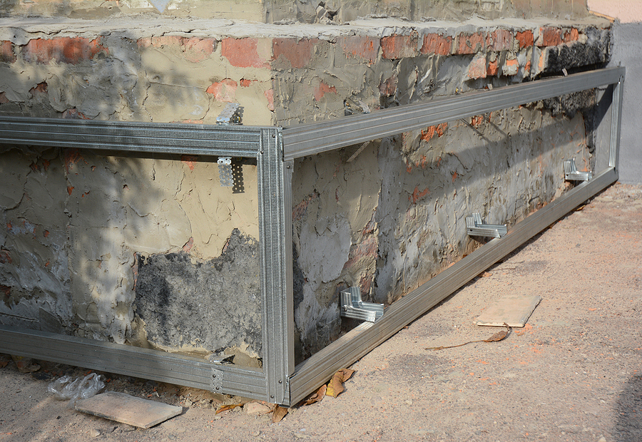 House foundation wall repair and renovation  with installing on frame metal sheets for waterproofing.