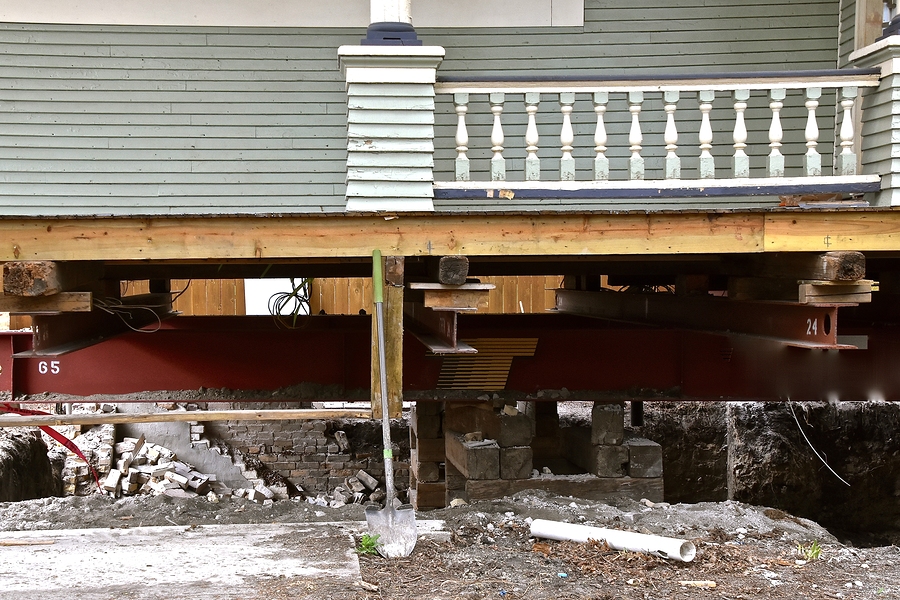 old house rests on steel girders as a new concrete basement and foundation is being created